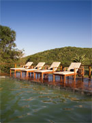 Lounge chairs glow in the setting sun beside the villa's private pool at Phinda Zuka Lodge, Phinda Reserve, South Africa.